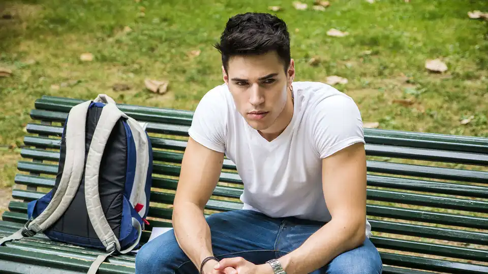 Young man wearing a white shirt and blue jeans.