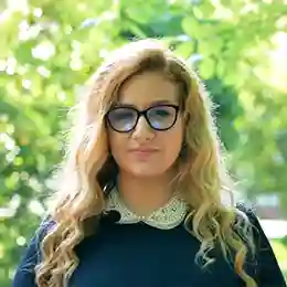 Blonde student wearing glasses.